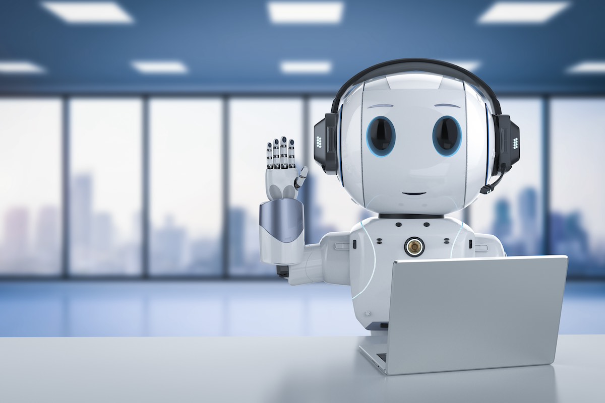 Robot sitting in front of laptop waving hello.jpg
